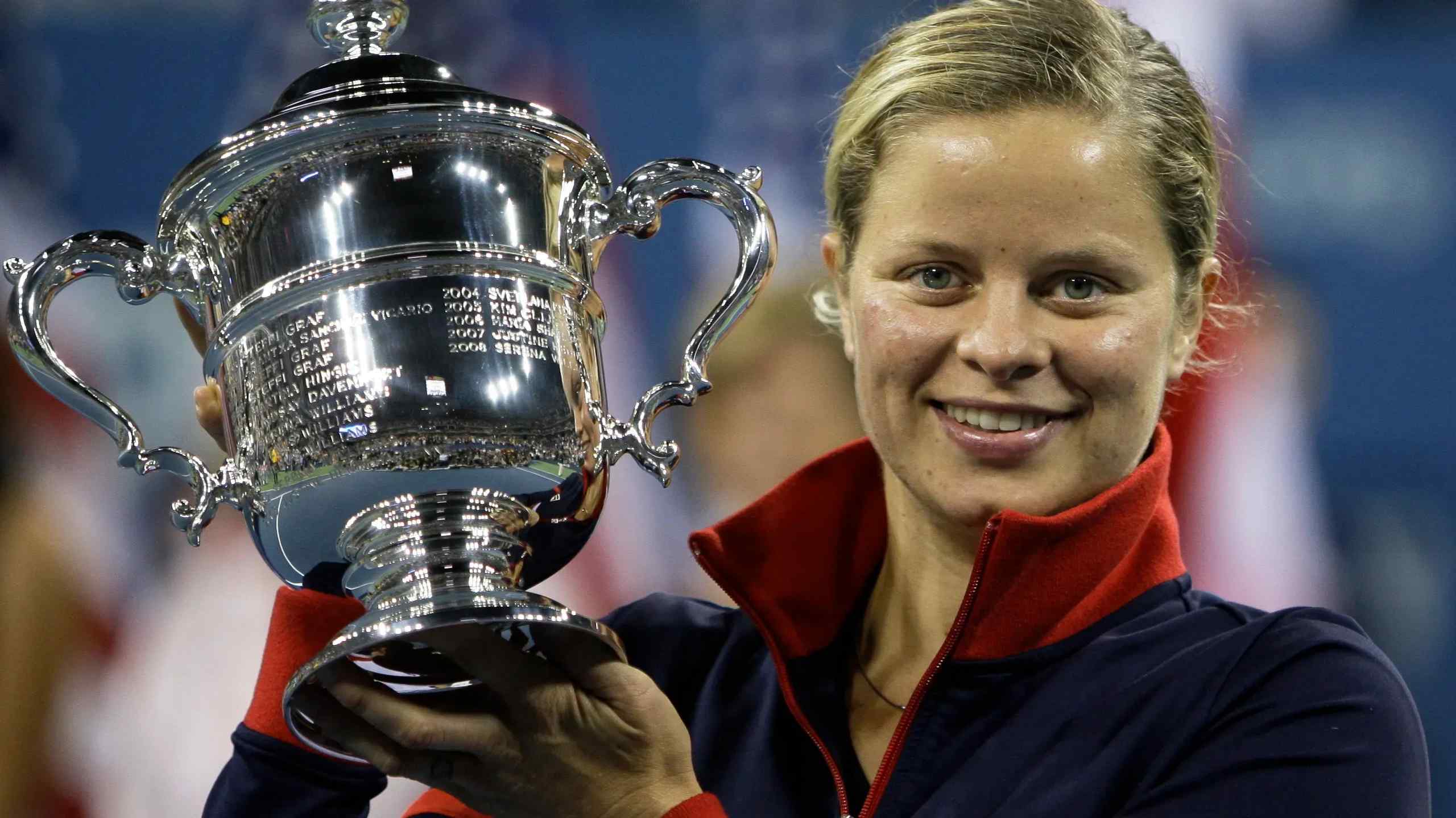Tennis star Kim Clijsters raising a trophy.
